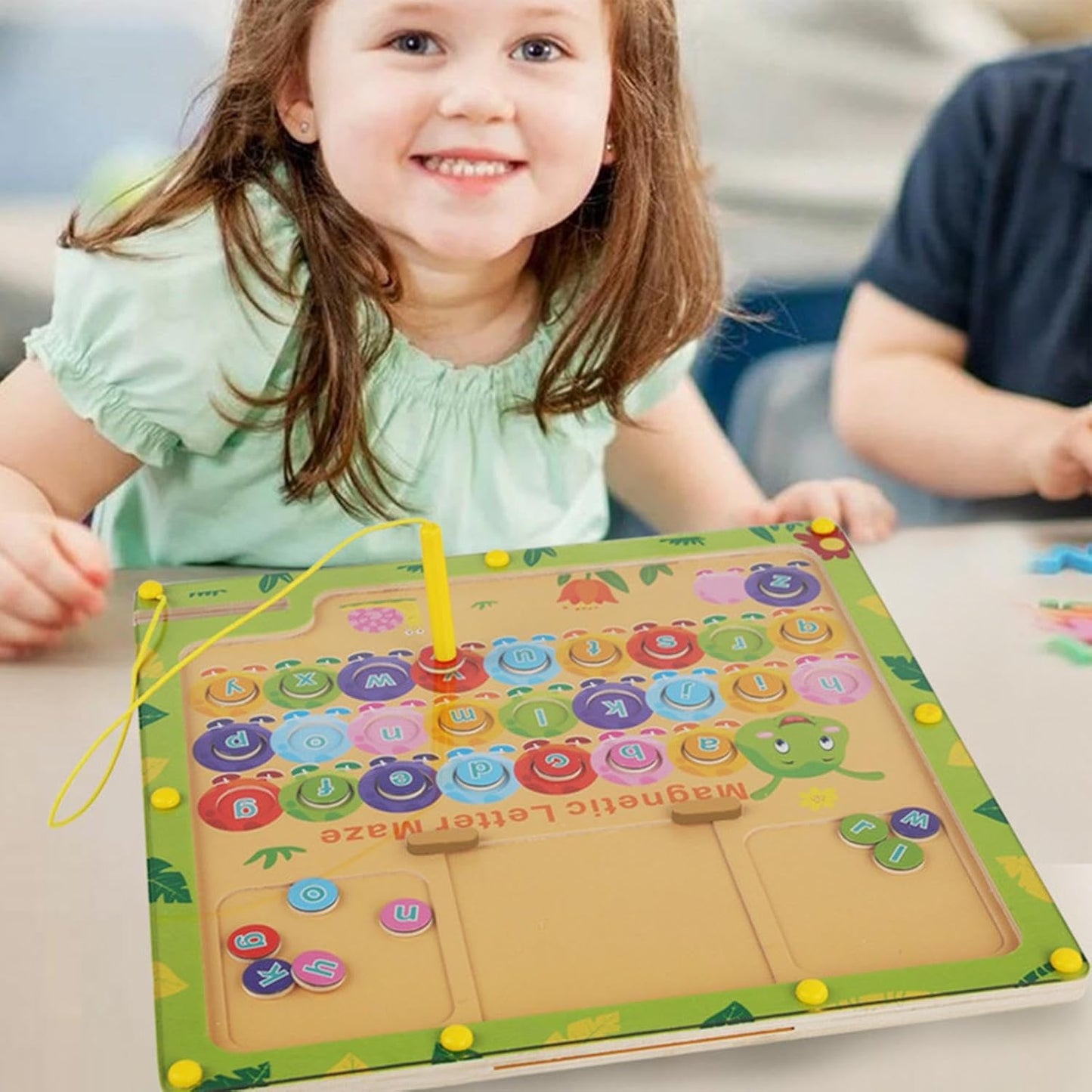 Child playing with a colorful educational toy on a table.